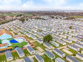 An aerial view of a holiday park with rows of mobile homes and a small outdoor pool area at Beachcomber's Base - Hayling Island in Hayling Island Holiday Park