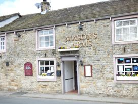 A stone building with windows flower boxes and a sign reading masons arms at Kingfisher Lodge in Gargrave