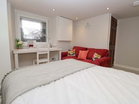 A bedroom with a bed, desk, and sofa at Poppy Cottage in Bowness-On-Windermere