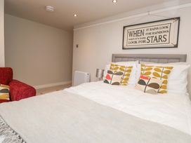 A bedroom with a bed and armchair at Poppy Cottage in Bowness-On-Windermere