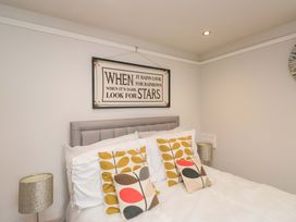 A bedroom with a bed and decorative pillows at Poppy Cottage in Bowness-On-Windermere