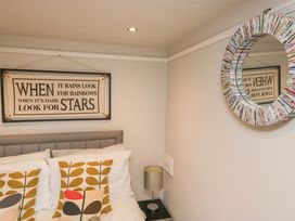 A bedroom with a bed and decorative items at Poppy Cottage in Bowness-On-Windermere