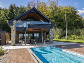A house with a pool and deck area at Forest Lodge in Pontyclun