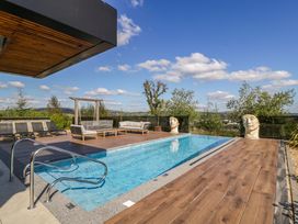 An outdoor area with a swimming pool and seating at Forest Lodge in Pontyclun