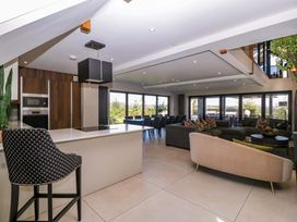 A living room with a kitchen island and dining area at Forest Lodge in Pontyclun