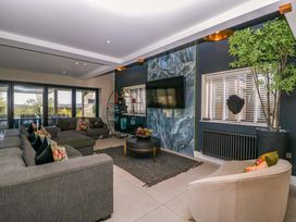 A living room with a sofa and television at Forest Lodge in Pontyclun