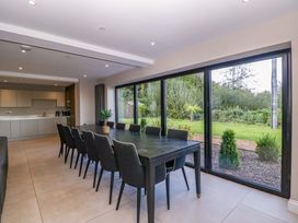 A dining room with a table and chairs at Forest Lodge in Pontyclun