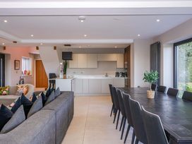 A kitchen with a dining area and a sofa at Forest Lodge in Pontyclun