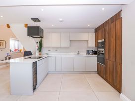 A kitchen with cabinets, sink, and appliances at Forest Lodge in Pontyclun
