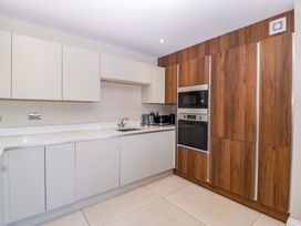 A kitchen with cabinets, sink, and appliances at Forest Lodge in Pontyclun