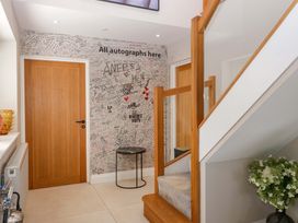A hallway with a staircase and signed wall at Forest Lodge in Pontyclun