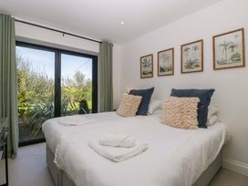 A bedroom with twin beds and framed pictures at Forest Lodge in Pontyclun