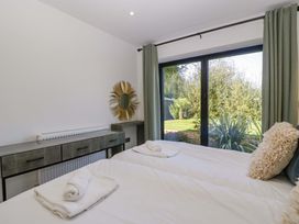 A bedroom with two beds and a window at Forest Lodge in Pontyclun