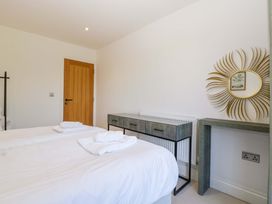 A bedroom with two beds and a bedside table at Forest Lodge in Pontyclun