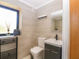 A bathroom with a toilet and sink at Forest Lodge in Pontyclun