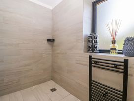 A bathroom with a shower and decorative items at Forest Lodge in Pontyclun