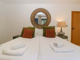 A bedroom with two beds and a lamp at Forest Lodge in Pontyclun