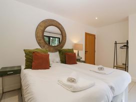 A bedroom with two beds and a lamp at Forest Lodge Pontyclun