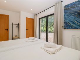 A bedroom with two beds and a window at Forest Lodge in Pontyclun