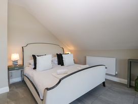 A bedroom with a bed and bedside lamp at Forest Lodge in Pontyclun