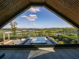 A room with a view of a hot tub and outdoor furniture at Forest Lodge in Pontyclun