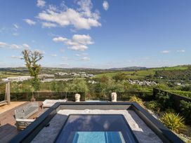 An outdoor space with a hot tub and seating at Forest Lodge in Pontyclun