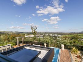 An outdoor area with a hot tub and garden sculptures at Forest Lodge in Pontyclun