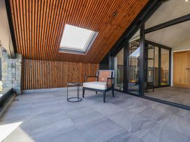 A seating area with an armchair and table at Forest Lodge in Pontyclun