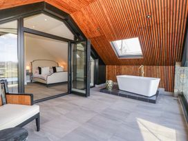 A bedroom with a bath and a bed at Forest Lodge Pontyclun