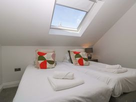 A bedroom with two beds and a skylight at Forest Lodge in Pontyclun