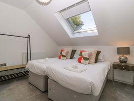 A bedroom with two beds and a skylight at Forest Lodge in Pontyclun