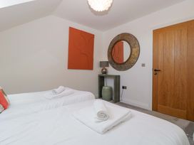 A bedroom with two beds and a mirror at Forest Lodge in Pontyclun
