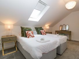 A bedroom with two beds and a lamp at Forest Lodge in Pontyclun