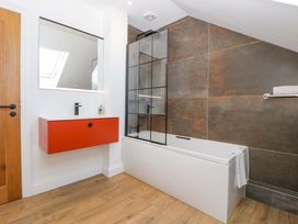 A bathroom with a bathtub and sink at Forest Lodge in Pontyclun