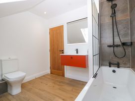 A bathroom with a toilet, sink, bathtub, and shower at Forest Lodge in Pontyclun