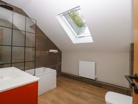 A bathroom with a bathtub, toilet, and sink at Forest Lodge in Pontyclun