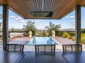 An outdoor area with a swimming pool and seating at Forest Lodge in Pontyclun