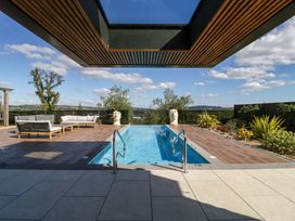 An outdoor area with a swimming pool and seating at Forest Lodge in Pontyclun