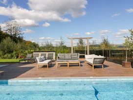 An outdoor area with seating around a pool at Forest Lodge in Pontyclun