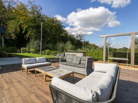 An outdoor seating area with sofas and a coffee table at Forest Lodge in Pontyclun