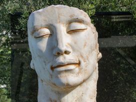A sculpture of a face surrounded by greenery at Forest Lodge in Pontyclun