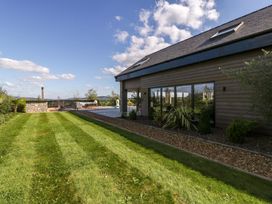 A garden with a pool and patio at Forest Lodge in Pontyclun