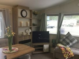 A living room with a television on a stand at 38 The Green