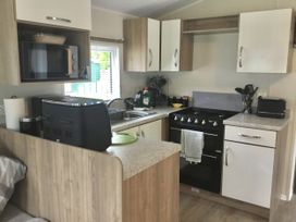 A kitchen with microwave and cooking range at 38 The Green