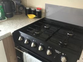 A gas stove with kitchen canisters and kettle at 38 The Green