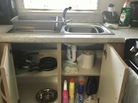 A kitchen with a sink and dish rack at 38 The Green