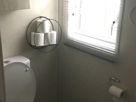 A bathroom with a toilet and toilet paper holder at 38 The Green