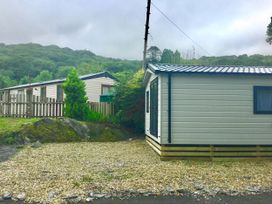 A cabin with a gravel area and trees at 38 The Green