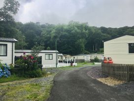A view of a caravan park with road and flower bushes at 38 The Green 