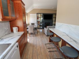 A kitchen with cabinets, countertop, and dining area at The East Wing Apartment in Claremorris